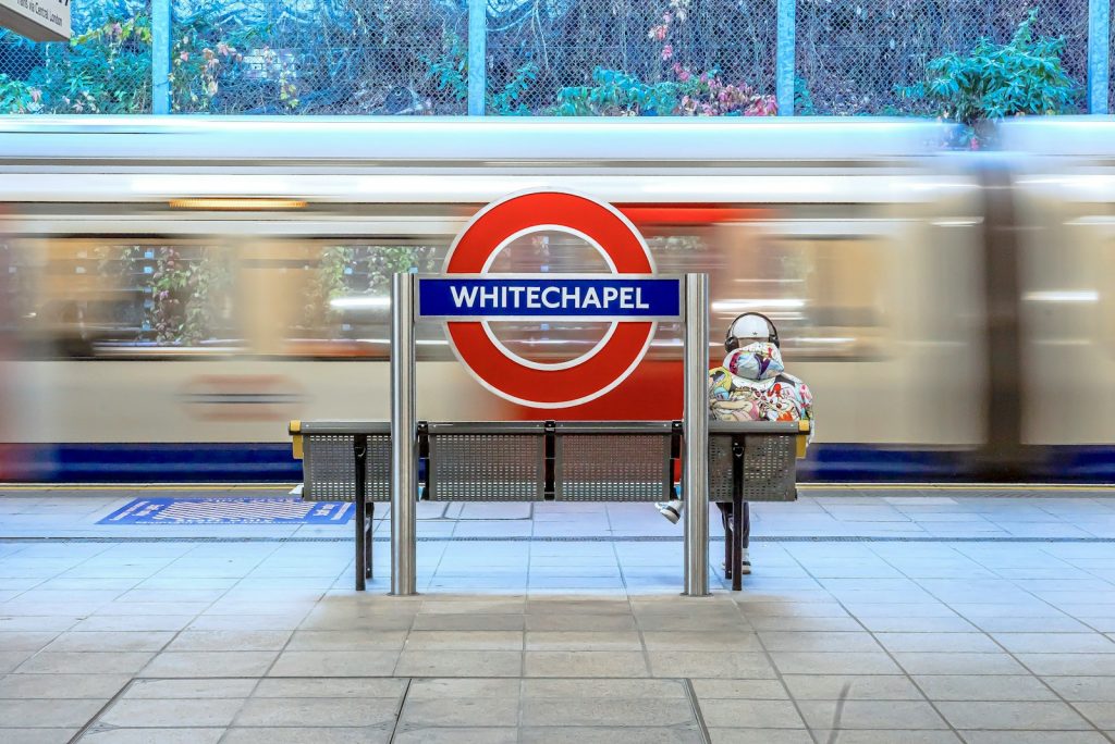 a person sitting on a bench in front of a train
